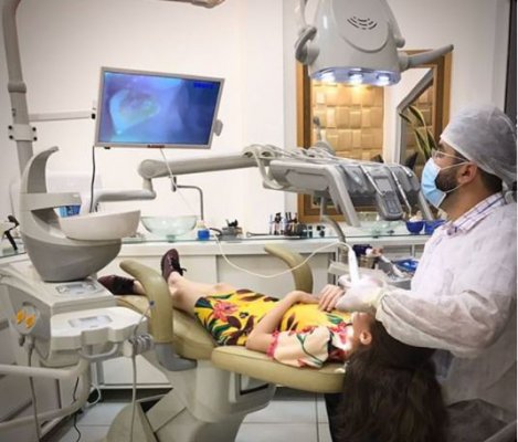 dentista analisando por vídeo os dentes de uma criança