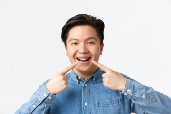 Adulto japonês sorrindo de aparelho