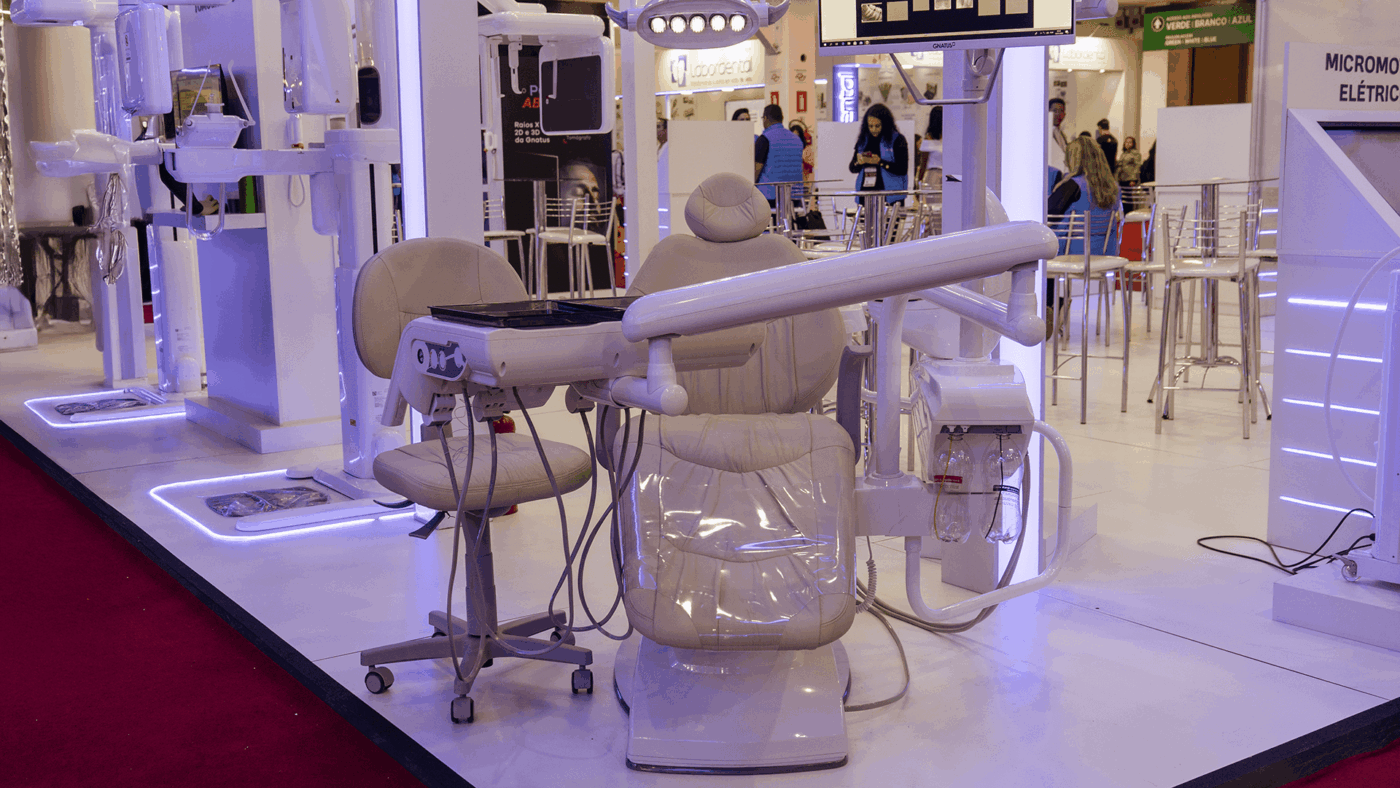 Cadeira de dentista exposta em feira odontológica, destacando um modelo moderno com equipamentos integrados, ideal para clínicas que buscam conforto e eficiência.