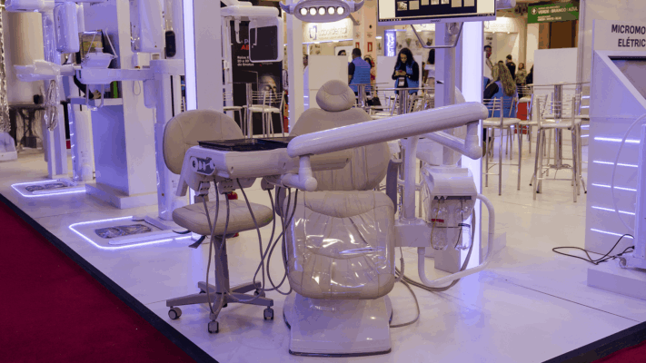 Cadeira de dentista exposta em feira odontológica, destacando um modelo moderno com equipamentos integrados, ideal para clínicas que buscam conforto e eficiência.
