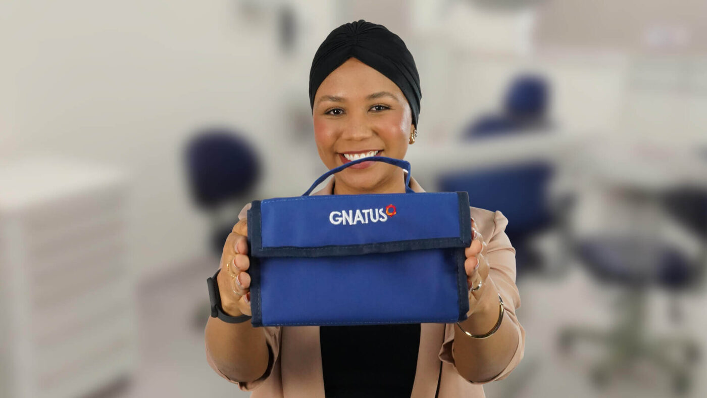 Estudante segurando kit acadêmico odontológico da Gnatus em ambiente clínico, destacando a importância da escolha dos materiais na formação prática