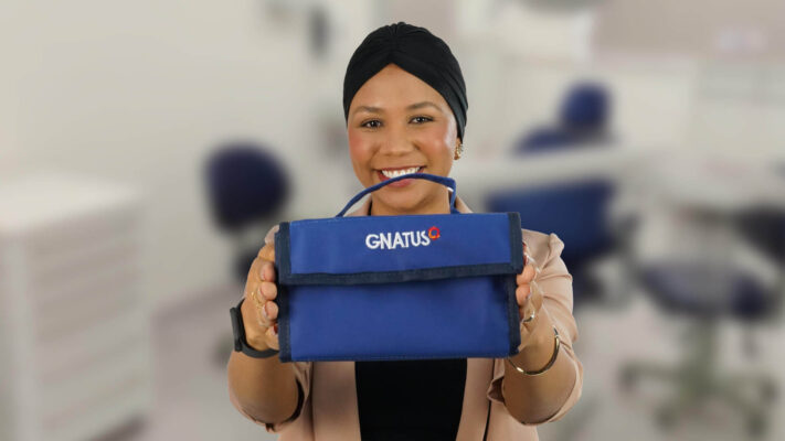 Estudante segurando kit acadêmico odontológico da Gnatus em ambiente clínico, destacando a importância da escolha dos materiais na formação prática