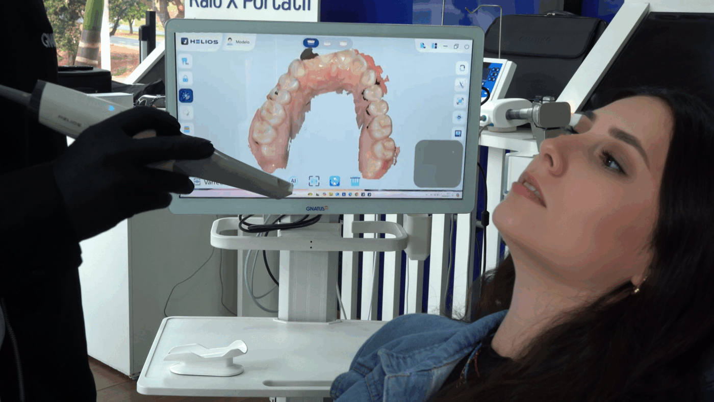 Scanner intraoral sendo utilizado em paciente com visualização digital 3D dos dentes na tela em clínica de odontologia moderna